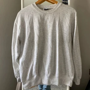 Grå sweatshirt - Säljer en klassisk grå sweatshirt med rund hals och långa ärmar. Perfekt för en avslappnad stil. Passar bra till jeans eller joggers.