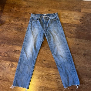 Blå Levis Wedgie Straight Jeans - Säljer ett par klassiska blå Levis Wedgie Straight jeans. De har en rak passform med en slitning vid foten.
