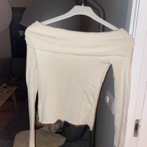 Beige/vit offshoulder topp från SHEIN - Säljer en stilren beige/vit  offshoulder topp från SHEIN. Toppen har långa ärmar och är tillverkad i ett mjukt och stretchigt material. jätteskön!!!