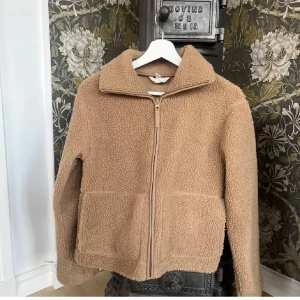 Beige teddyjacka med dragkedja - Säljer den populära teddy jackan från hm som är slut såld. Mysig beige teddyjacka med hög krage och dragkedja framtill. Jackan har två stora fickor och är perfekt för kyligare dagar. Den har en avslappnad passform och är superbekväm att bära. Vid snabb affär 250kr❤️ storlek M men sitter som en S