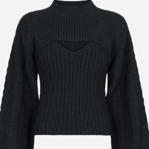 Svart ribbad tröja från Neo Noir - Säljer en stilren svart ribbad tröja från Neo Noir. Tröjan har en unik design med en cut-out detalj vid halsen och långa ärmar. Perfekt för att ge en trendig touch till din outfit. 🖤(Den är helt ny och oanvänd)