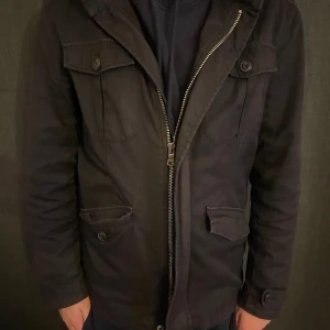 Svart fieldjacka med dragkedja - Snygg svart jacka med dragkedja och knappar. Jackan har flera praktiska fickor. Perfekt för kyligare dagar. Från Zara sicket är 8/10. Nypris 1299kr.                                 Mitt pris är 799kr