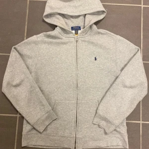Grå Ralph Lauren Zip Hoodie - 9,5/10 skick | knappt använd | snyggt och fräscht att ha inför våren | Säljer pga den är liten på mig| Storlek : S | skriv för fler frågor och bilder | priset blir billigare vid snabb affär 