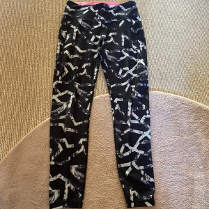 Leggings - Snygga svarta leggings med ett unikt mönster i vitt och grått. De har en normal midja design med en rosa insida i midjan för extra komfort. Perfekta för träning eller en avslappnad dag.😻De är mjuka och sköna som sitter tajt efter din figur💕Står storlek S, men kan även passa XS💋