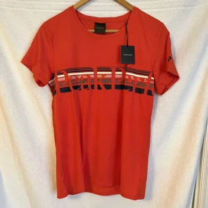 T-shirt - Helt ny ljusröd t-shirt från peak performance i storlek M.