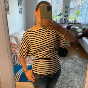 Randig topp - Randig topp från H&M som är tight vid midjan vilket e super snyggt. det är en dragkedja på sidan och ärmarna är ungefär till armbågarna🥰