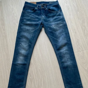 Dondup jeans  - Snygga blå dondup jeansbyxor med en klassisk femficksdesign. De har en lätt slitning på framsidan som ger en trendig look. Perfekta för en avslappnad stil. Modell George i storleken 29 sitter som 30, nyskick. Vid fler frågor så är de bara att skriva. Dom e lite mörkare blå 