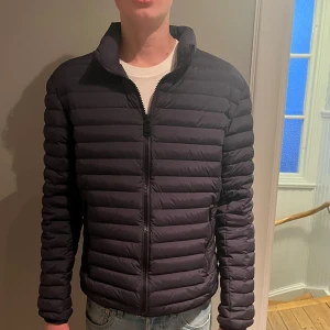 Mörkblå pufferjacka från Colmar - Säljer en snygg mörkblå pufferjacka från Colmar. Jackan har en dragkedja framtill och är långärmad. Perfekt för kyligare dagar med sin quiltade design. Den har en normal passform och är tillverkad i syntetmaterial. På fjärde bilden ser man att man nye kan hänga upp jackan men detta kan man enkelt fixa. Hör av er vid frågor eller funderingar!!!