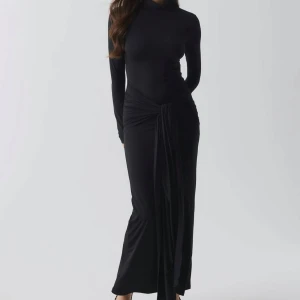 Svart långklänning med öppen rygg - Klänning från Ginatricot som är ny, samt med prislappen fortfarande kvar. Säljes pga fel storlek. 