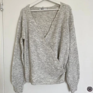 Stickad omlotttröja från NA-KD!🤎🧸 - Säljer en supermysig grå omlotttröja från NA-KD i storlek S. Koftan har långa ärmar och en omlottdesign! Perfekt att matcha med jeans eller en kjol för hösten. Tröjan är helt oanvänd!🫶🏻🎀🫧