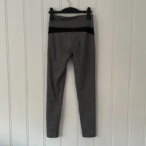 Träningstights  - Grå träningstights med svarta detaljer. Storlek 34. Knappt använda, jättefint skick! 