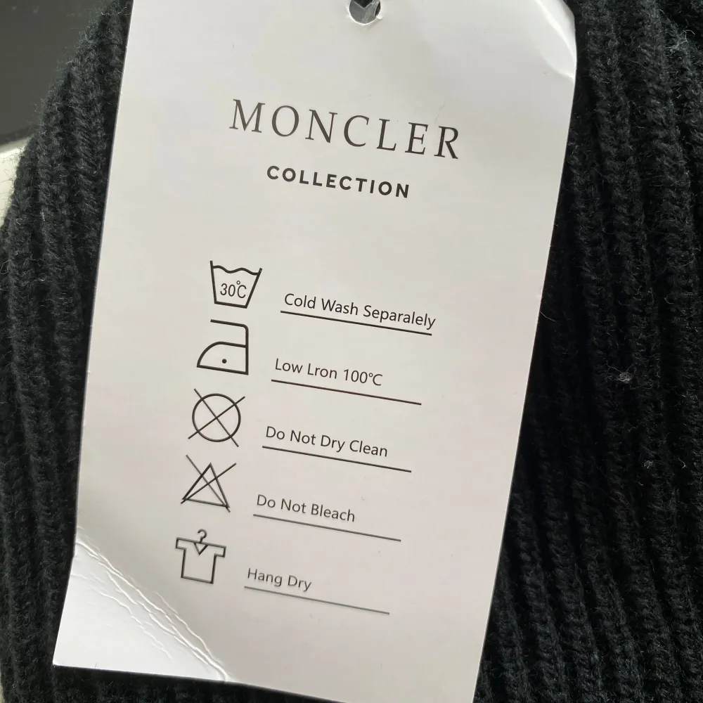 Säljer en snygg svart stickad mössa från Moncler. Den är i nyskick och har Monclers ikoniska logga broderad på framsidan. Perfekt för att hålla sig varm och stilren under kalla dagar. Tvättråd: kalltvätt separat, låg strykning, ej kemtvätt eller blekning, hängtorkas.. Accessoarer.