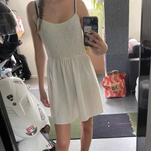 Vit sommarklänning - Superfin kort vit klänning med spetsdetaljer. Perfekt till sommaren, student eller konfirmation.   Den är lite lätt genomskinlig men den funkar med shorts under