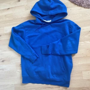 Hoodie  - En blå hoodie som knappt är använd då den inte sitter på mig som jag vill. 
