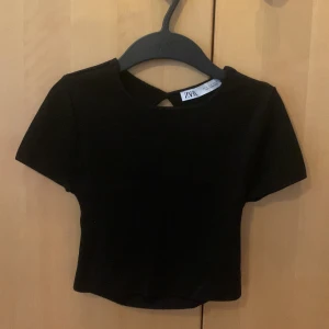 Croppad Zara topp med öppen rygg - Säljer en svart croppad Zara topp i storlek S med öppen rygg. Köpt för något år sen men knappt använd. 