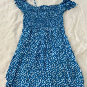 Blå blommig klänning från FB Sister - Säljer en superfin blå klänning från FB Sister med ett sött blommigt mönster i väldigt bra skick.
