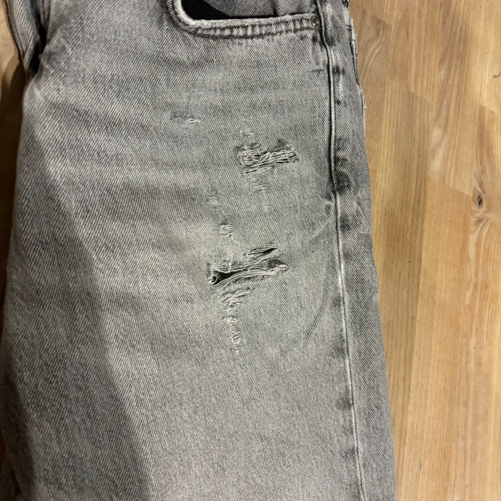 Säljer ett par grå jeans från Zara i storlek EUR 42. De har en sliten look med några snygga slitningar på framsidan. Perfekta för en casual stil och passar till det mesta. . Jeans & Byxor.