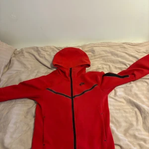 Röd hoodie från Nike - Säljer en röd nike hoodie väldigt fin och mycket bra pass form, liten skada på framsidan men inget som syns alls utöver de inga andra skador.