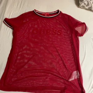 Guess tröja - Den är röd med guess text på och sen är den genomskinliga.