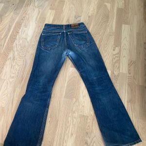 Blåa jeans från Lee - Mörkblåa vintage jeans ifrån lee, slitna mellan benen men går lätt att du ihop, en vintage könsla jeansen är ifrån år ca 2000 så går ej att få tag på längre.