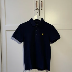 Lyle & Scott Piké - Superfin Lyle & Scott piké i en jättesnygg navy färg. Säljer då jag har växt ur den. Fint skick utan defekter. Skriv vid frågor eller funderingar!!
