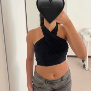 Halterneck Topp Svart - En svart halterneck topp som aldrig har använts. Passar perfekt till sommaren och i vardagen! Normal i storleken.