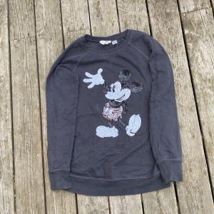 Grå tröja med Musse Pigg från Disney - Säljer en superfin grå tröja med Musse Pigg-motiv från Disney. Tröjan är i storlek S och har långa ärmar. Perfekt för en avslappnad stil och passar bra till jeans. Den är i bra skick och redo för nya äventyr! 🐭✨   Kontakta helst innan köp. Jag tvättar innan jag skickar iväg den och tar bort eventuella fläckar 💕