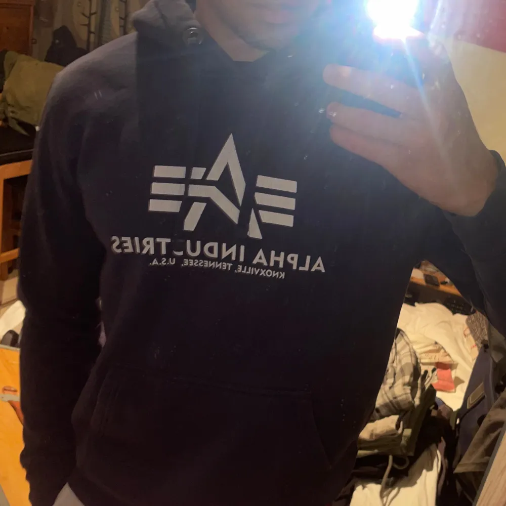 En fin blå alpha industries hoodie av bomull, använd sparsamt. texten på framsidan är en bit urtvättad. Hoodies.