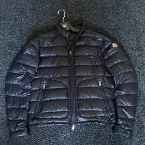 Svart dunjacka från Moncler - Säljer en snygg svart dunjacka från Moncler. Jackan är i nyskick och har en normal passform.Perfekt för höst och vinter!