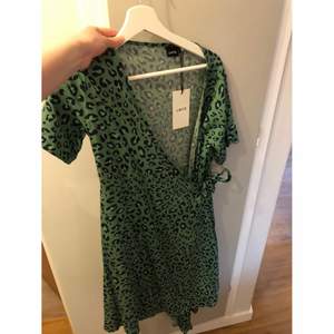 Grön leopardmönstrad klänning aldrig använd, nypris 399 kr.                                                                                 Storlek 176, Pris 100 kr,                                               Kan skickas mot fraktkostnad 66 kr