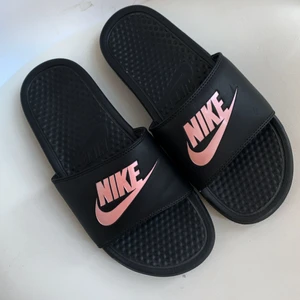 Nike badtofflor - Badtofflor från Nike med rosaglittrig nikelogo. Är i nyskick. Strl 39 men rekommenderad dem till en 38 (funkar även på 39 men de flesta föredrar att tofflorna är lite större än deras fot). Nämn ett pris som känns rimligt för dig vid intresse!