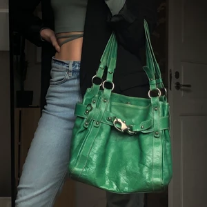 Axelväska i Nappaskinn - Grön handväska i äkta läder. Köpt i en exklusiv secondhand butik. Mycket fint skick, med mindre slitningar på undersidan av väskan. Gjord i Italien. Två innerfack.  Frakt är inte inkluderat i priset🌸