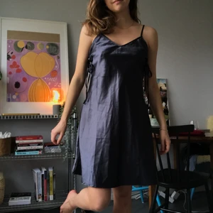 Mörkblå siden miniklänning - Mörkblå kort lite utsvängd klänning i siden, med knytning på sidorna. Tyvärr för stor för mig. 