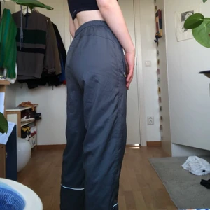 Umbro byxor - Supersnygga UMBRO byxor i grå! Köpta second hand men aldrig använda av mig och är i bra skick! De är ganska högmidjade med har en snygg vit rand på insidan så går även att vika ner om man önskar en lite lägre midja. Kan mötas upp, annars tillkommer frakt