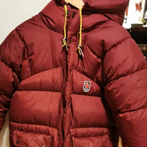 Fjällräven  - Fjällrävenjacka i storlek xxxs (men gigantiska i storleken, motsvarar en S). Den är vinröd i färgen. Väldigt bra skick förutom två små hål på ena armen. Köparen betalar frakt😊