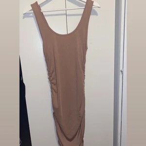 Tight klänning - Säljer min enbart testade klänning, ljusbrun/sand färgad då jag inte trivs i färgen. Har en tight passform, speciellt baktill. Köpt i utlandet i somras, nypris 250kr. Storlek S men passar även XS.