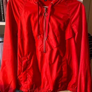 Röd anorak från h&m Divided!  - Helt nytvättad och har inte den minsta skråma eftersom använts endast någon enstaka gång. Lika lysande röd som på bilderna !! 