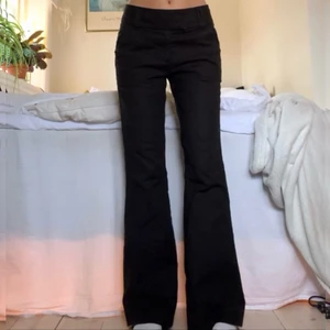 Svarta kostymbyxor - Svarta lågmidjade utsvängda kostymbyxor med snygga detaljer! Passar mig som är 173 cm och innerbenslängden är ca 78 cm 💘