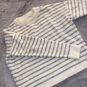 Stickad tröja  - Stickad tröja från NAKD. Andvände ett fåtal gånger. Storlek: S. Den är vit med ljusgråa ränder. Sticks inte. 