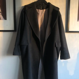Grå ullrock från H&M - Säljer en oversize mörkgrå rock från HM i storlek 34! Använt skick, har tappat knappen men finns en extra i tvättlappen! 51% ull 35% polyester 14% ”andra fibrer” 🌟