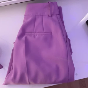 Zara trendiga lila byxor 💜 - Lilla Sara byxor jättefina trendiga byxor som har en matchande skärp. använd några gånger är det bra skick 💜