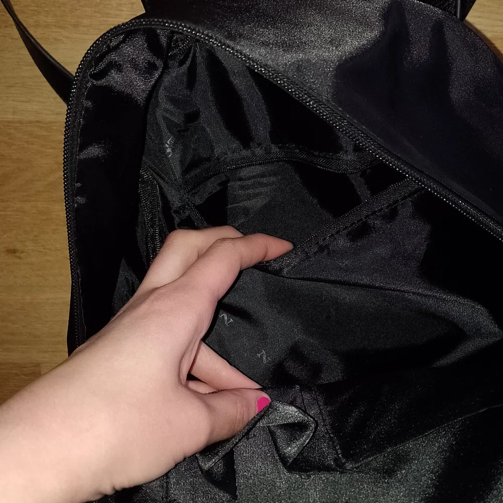 Black practical backpack, bought this summer. Since I have too many bags, I ended up not using it so it is in mint condition. Colour is not faded, it is truly black and has pockets inside of it as shown on the last picture, and one big front pocket with a zip. Ruler of 30 cm for scale. It can comfortably fit a student laptop and even has a division inside for it. Outer impregnation makes it waterproof.. Väskor.