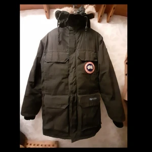 Canada Goose parka  - Skick: 5/10 - Strlk: M - Herr                                               En varm vinterjacka från Canada Goose i ett okej skick. Jag köpte jackan begagnat så därför medföljer inget kvitto eller intyg men pälsen är äkta och jackan med. Storleken som står i jackan är "XXS/2TP" men den sitter som en storlek: M. Jackan har en del lagningar på ärmarna och i enstaka sömmar, men annars så är den en fin jacka. Om det är något ni undrar över så är det bara att höra av er!