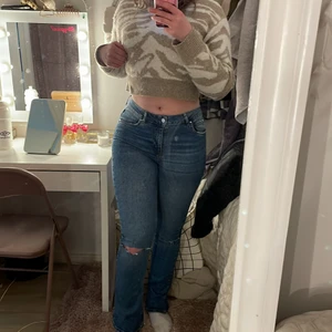  Jeans  - Jeans från ginatricot som är utsvängda och har hål vid knäna och är mörk blåa 