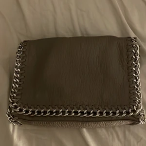 grå tiamo väska - jättefin grå väska ifrån tiamo! stor och rymlig med många fack och fickor! använd några gånger under hösten men inga defekter, i princip i nyskick! nypris 550 kr