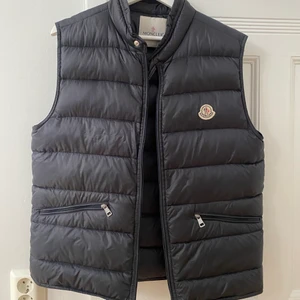Moncler väst - Säljer min pojkväns Moncler väst som är använd men i fint skick. Sklart ÄKTA!! Den är matt och svart. Storlek 5 vilket passar på honom som har L 🙌