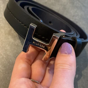 Bälte från Tommy Hilfiger - Svart bälte från Tommy Hilfiger, mörkblått på insidan. I byxor har jag ofta storlek 36/34. Knappt använt!  Hör gärna av er om fler bilder🥰