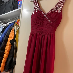 Balklänning - Superfin lång balklänning i vinrött med dekorativa stenar högst upp. Är något uppsydd, hade denna till 14 cm klackar och jag är 160. Strl 8, dvs s-m