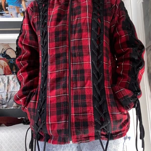 Gothicana by EMP kofta - Jättecool rutig varm kofta med snörning. Använd fåtal gånger i relativt bra skick, dock nopprig men inget som syns jättemycket.  Katt i hemmet. Kan mötas upp i Uddevalla centrum om ej så står köparen för frakten. 