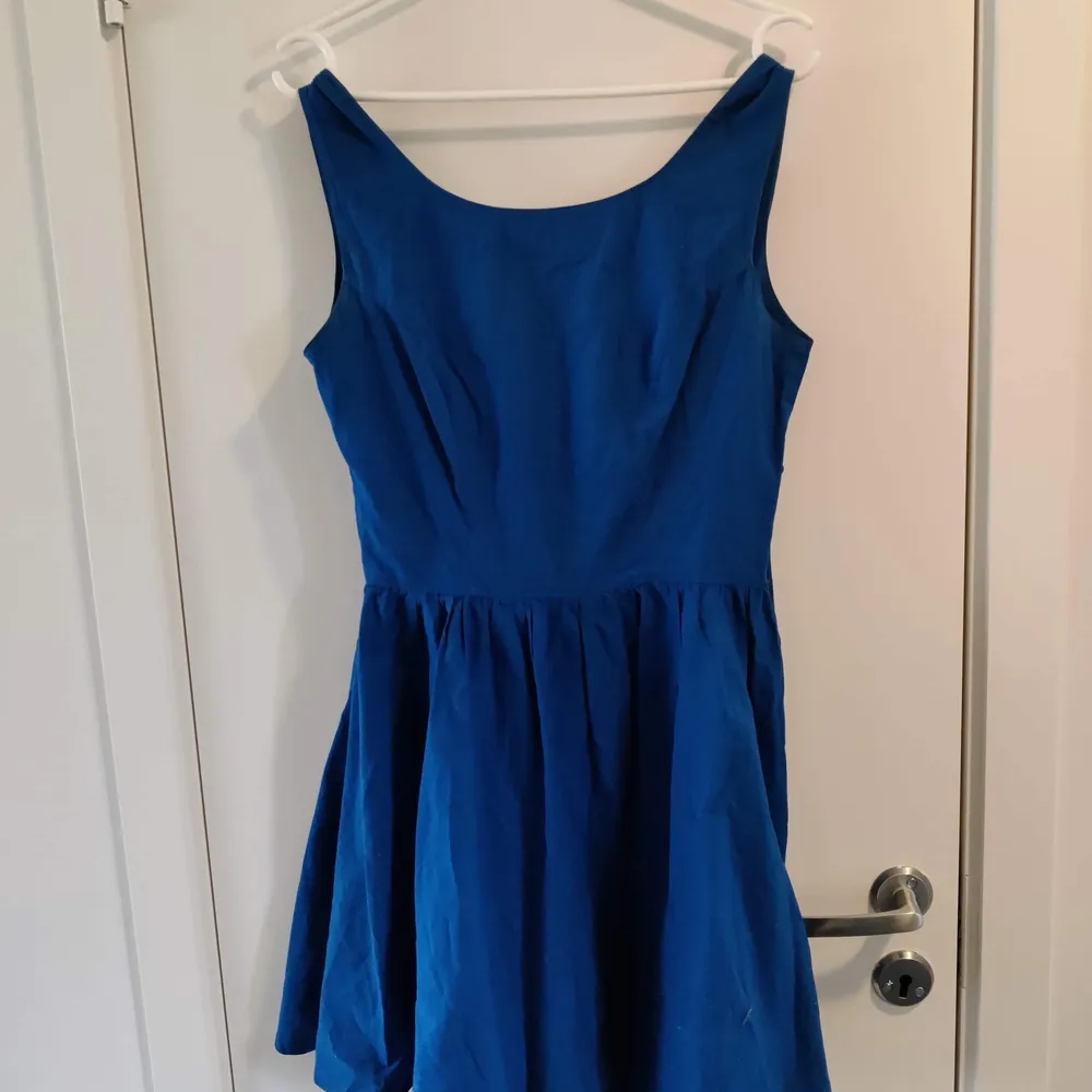 Jättefin blå klänning med knyt i ryggen. Ca fingertoppslängd på kjolen. Ger ett härligt 50-tals stuk.. Klänningar.
